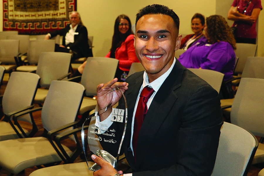 Scholarship winner holding a glass plaque